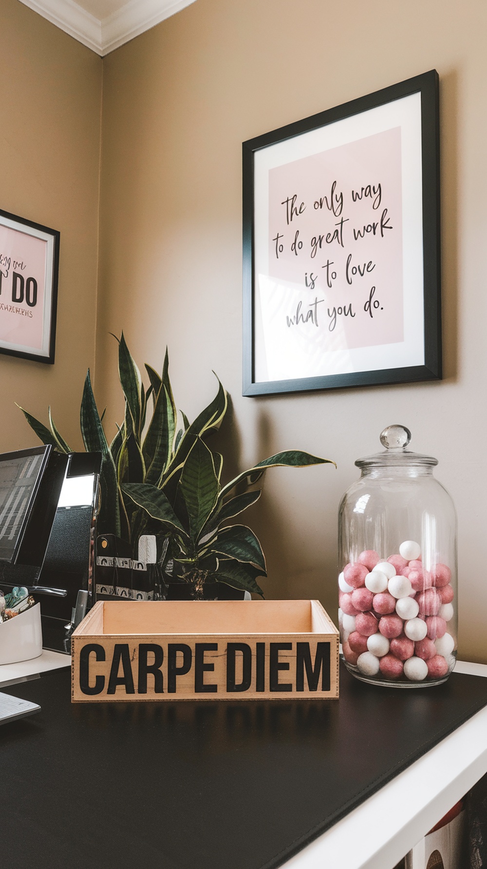 A desk with motivational decor including a framed quote, a wooden box saying CARPE DIEM, a plant, and a jar of colorful gumballs.